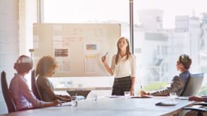 A woman pitching new business in a board room.